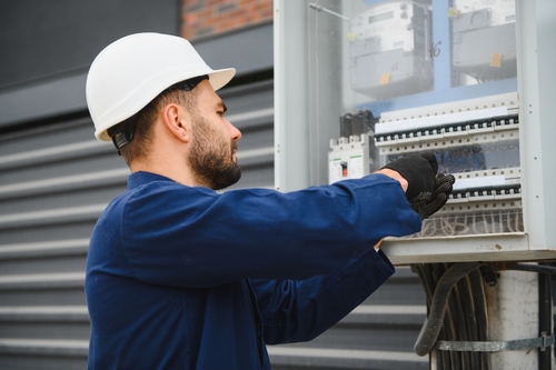 An electrician works on a panel.