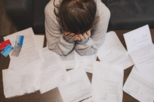 Stressed person reading documents about student loans.