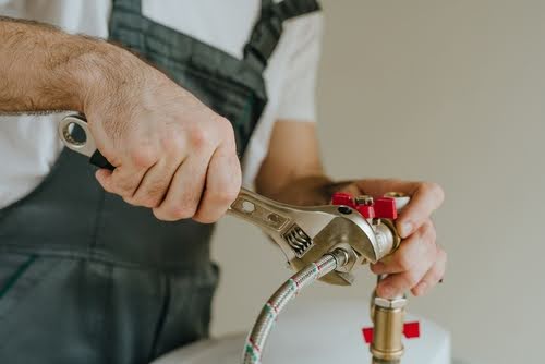 Hands of plumber working.