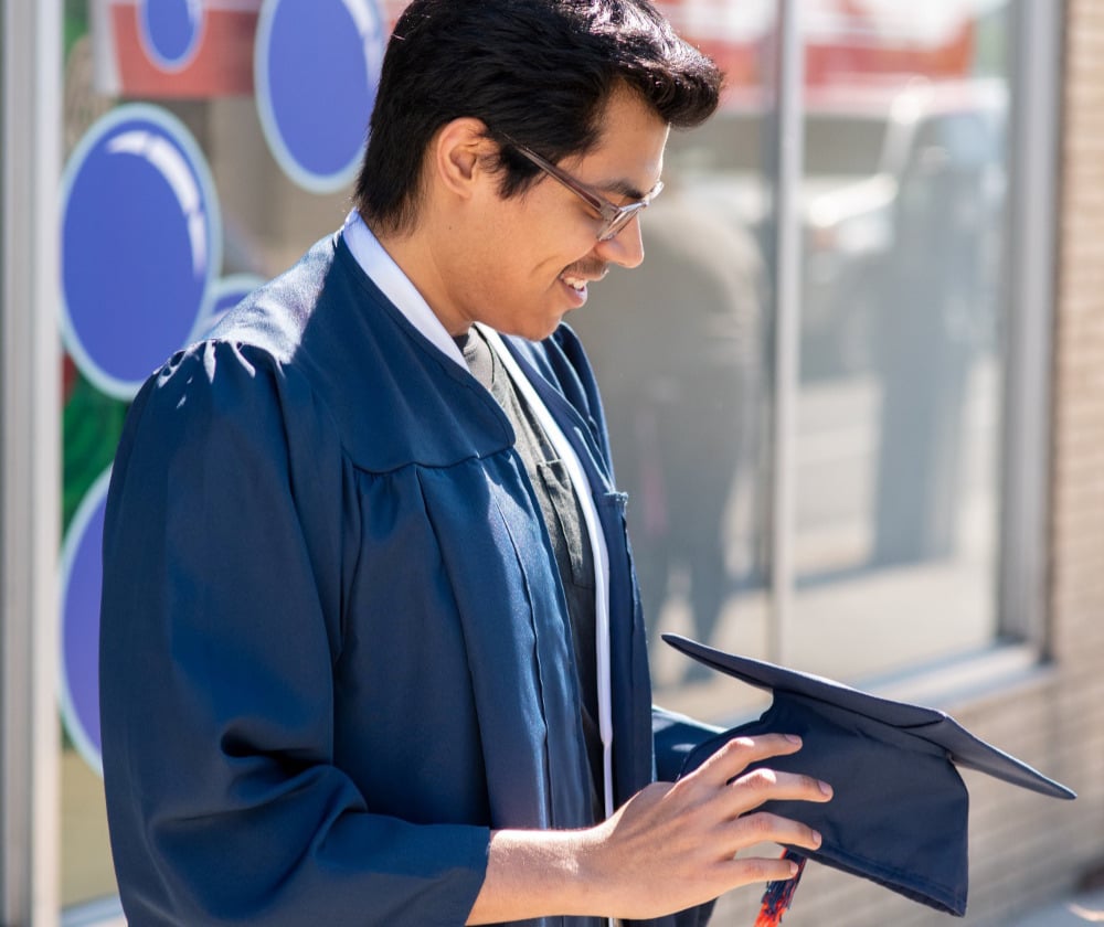a young man wearing a blue graduation robe
