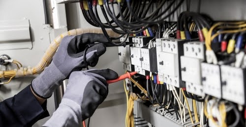 Electrician engineer tests electrical installations and wires on relay protection system. Adjustment of scheme of automation and control of electrical equipment.