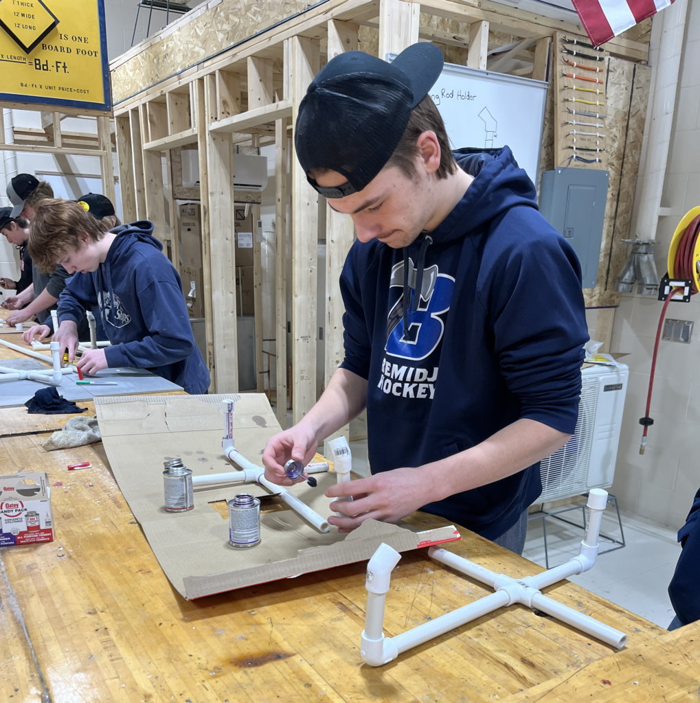 Male student working on plumbing.