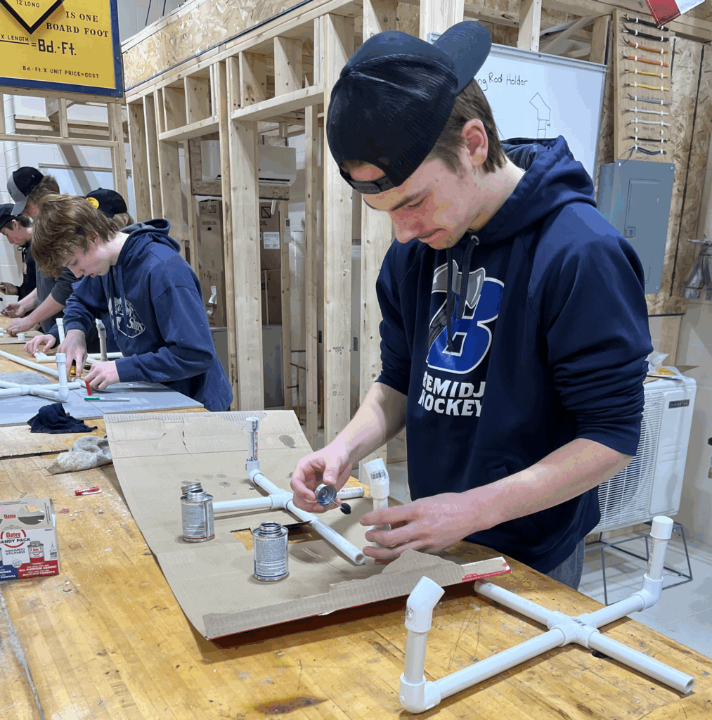 Male student working on plumbing.
