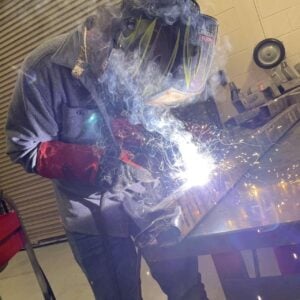 Student with a welders mask welding