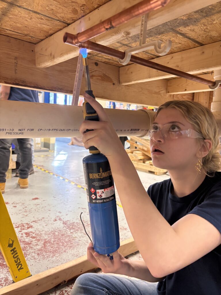 Young female student working on plumbing