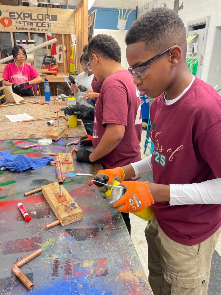 Young male student working on plumbing.