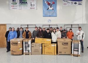 Students standing next to boxes of tools
