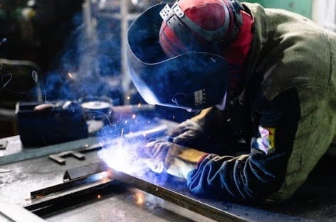Welder working on project with sparks.