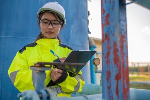 Trades worker with clipboard and hard hat.