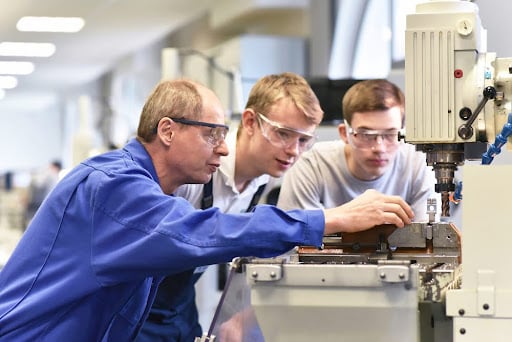Group of young people in technical vocational training with teacher.