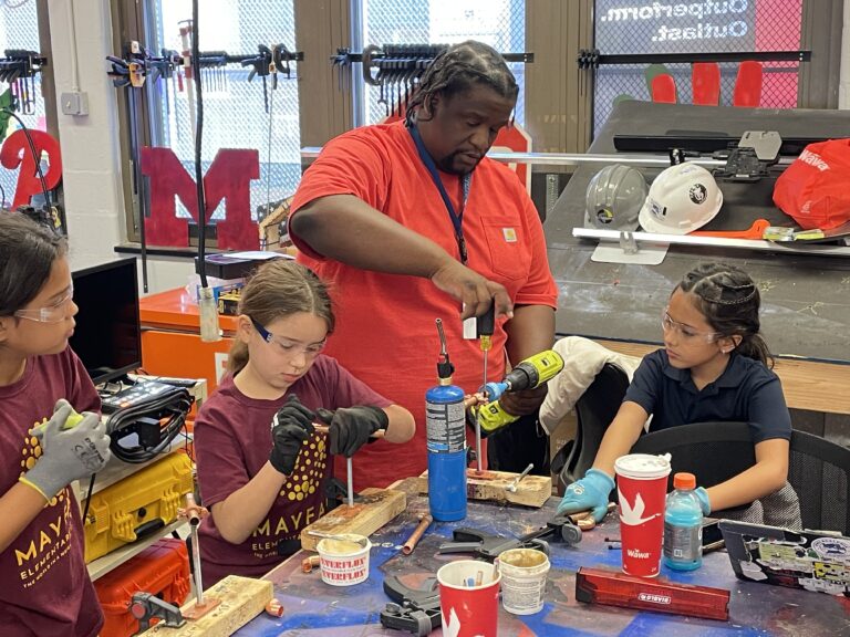 Teacher with students in classroom learning the skilled trades.