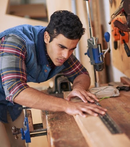 Young tradesperson working with plywood.
