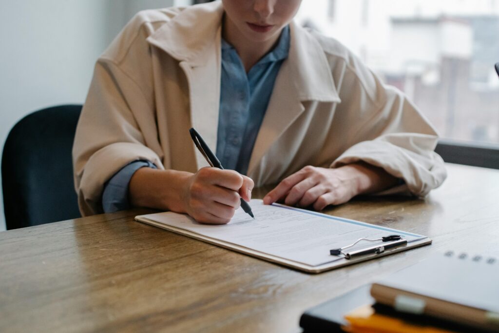 woman writing on a clip board