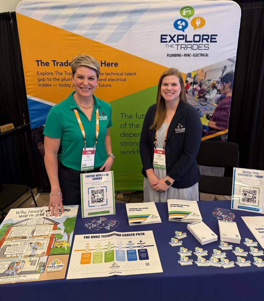 Two Explore The Trades representatives smiling at a branded booth displaying career pathway materials at the Lennox Live 2026 event.