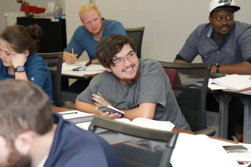 An apprentice smiles in class.