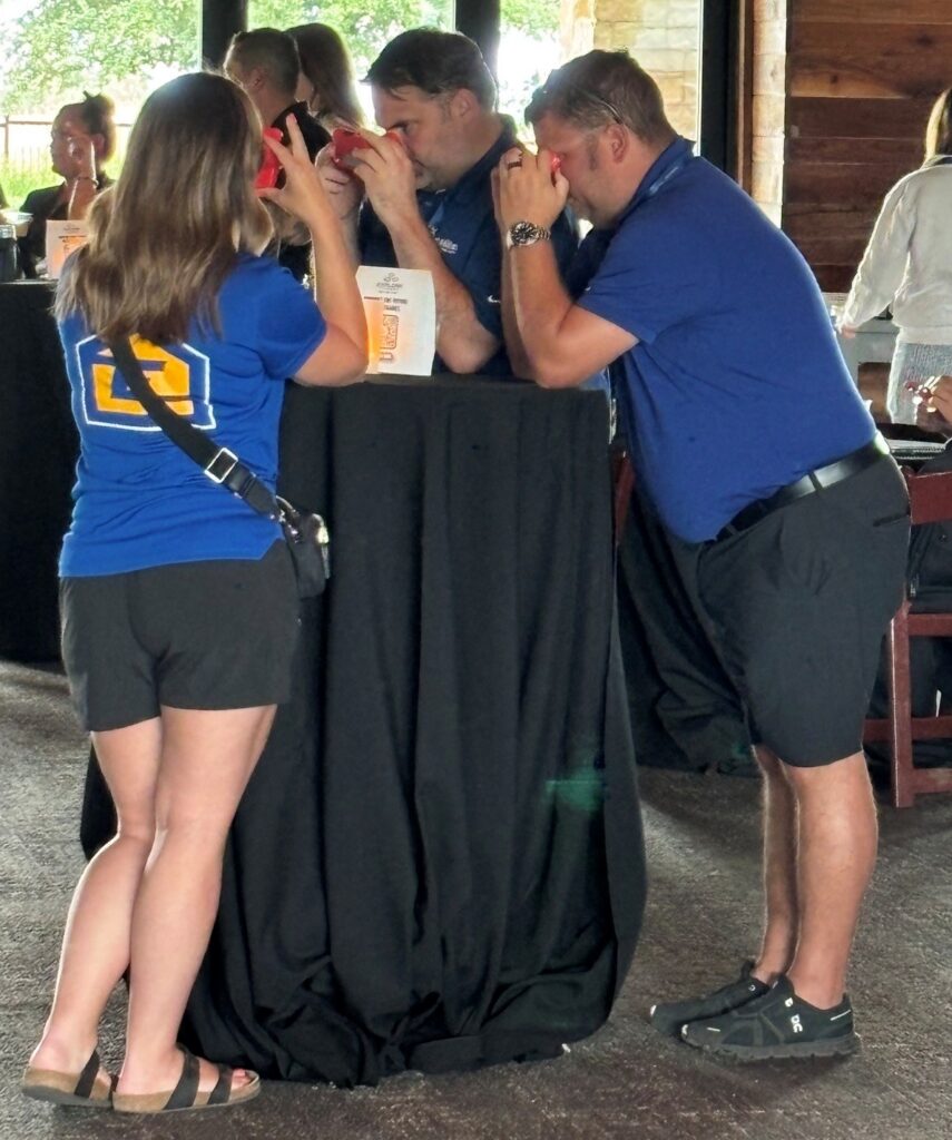Three people look at pictures through ViewFinders.