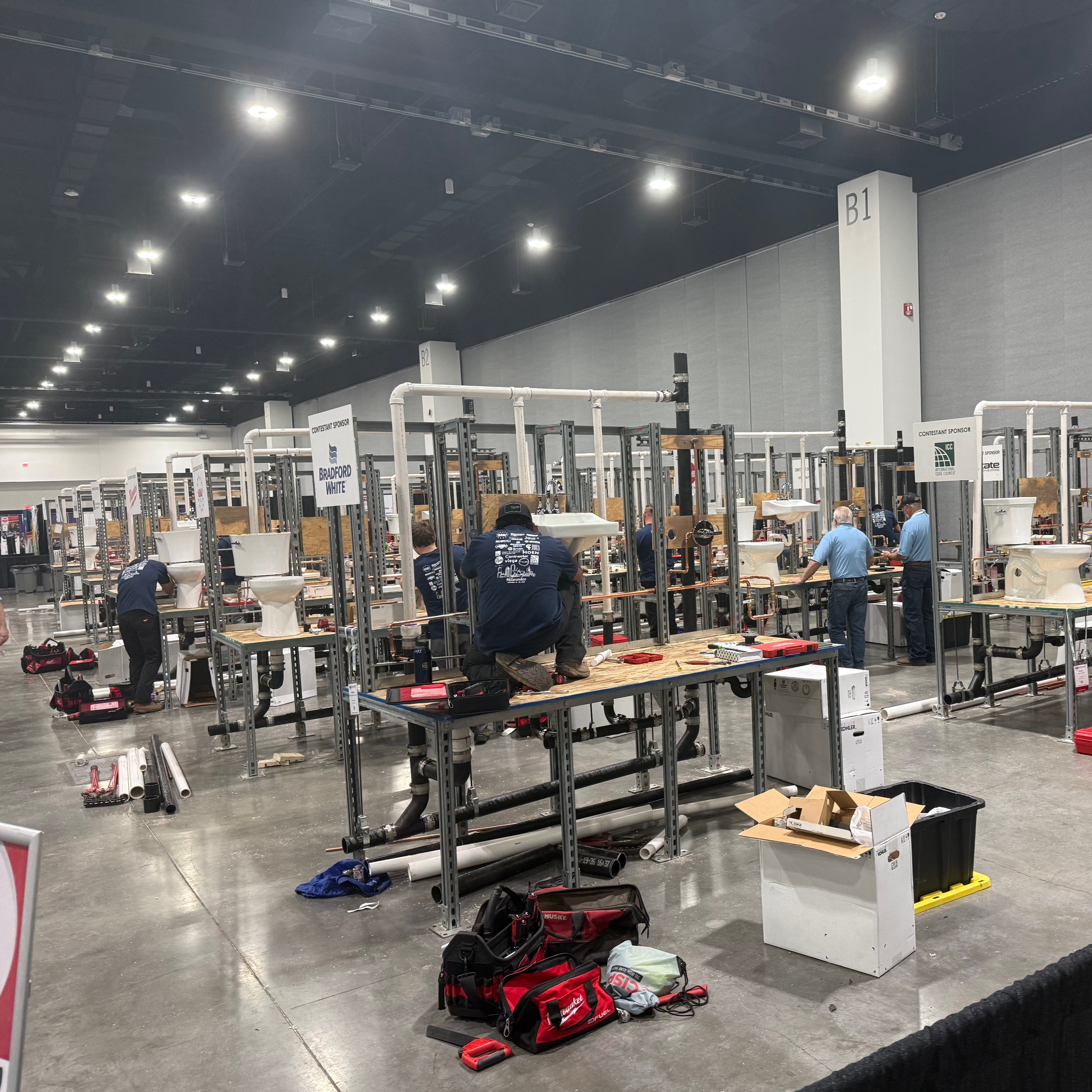Students working at HVAC skills lab stations on a trade show floor